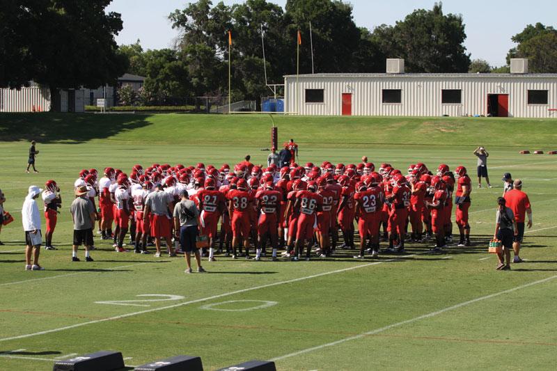 The football team gathers for a post practice speech from head coach DeRuyter on Aug. 23.  The depth chart for positions will be finalized this week.
Dalton Runberg / The Collegian