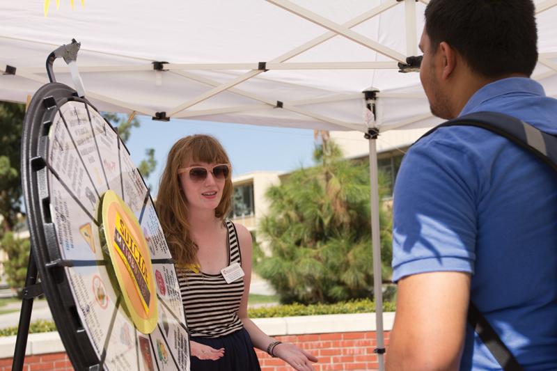 The Suicide Prevention Program informational booth uses a spin-the-wheel Suicide Mythbuster to engage students. Josephine Gildersleeve explains to Sunvir Johal, an enviromental occupational health student, about the two-year grant the program recieved this year. 
Roe Borunda / The Collegian