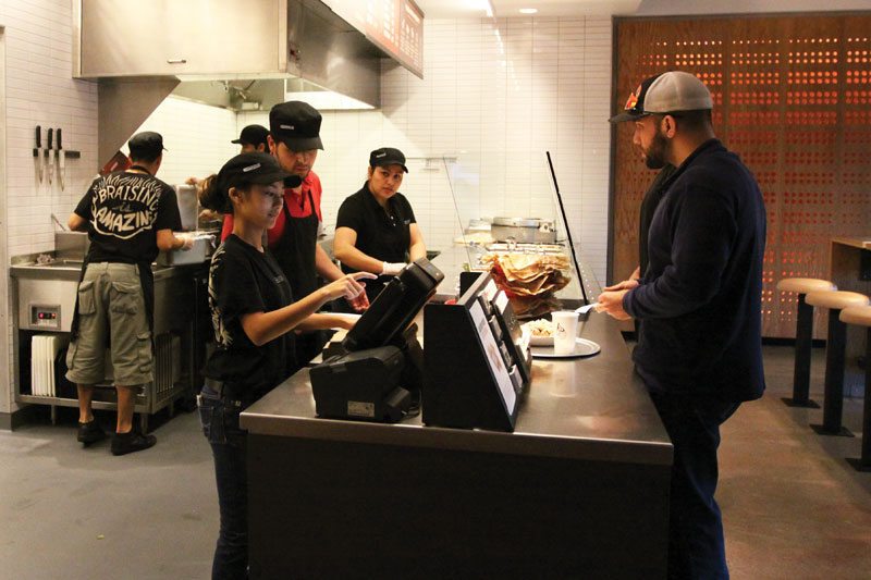 Ia Thao, a Fresno State freshman, works the cash register at the new Chipotle location on Shaw and Cedar avenues. Many of the employees of the restaurant are Fresno State students.