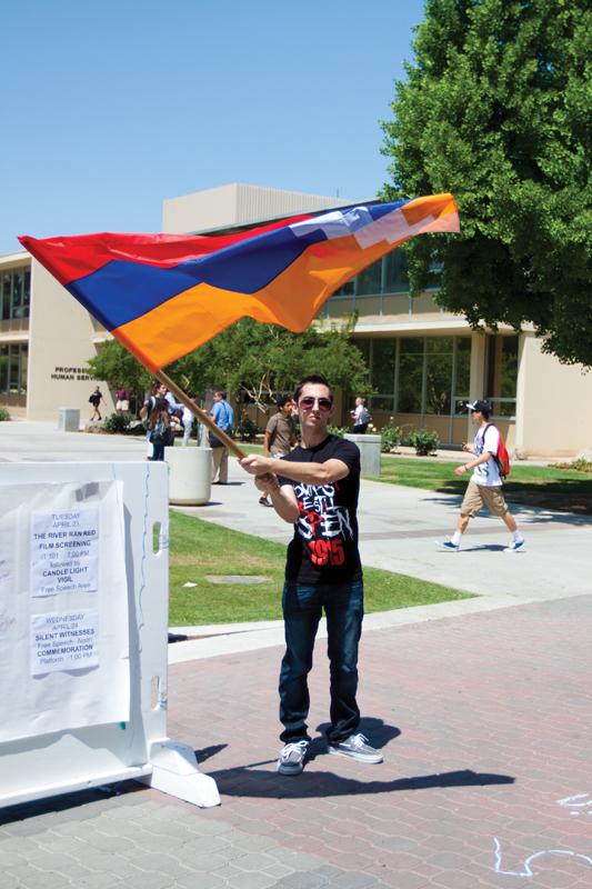 A student with Fresno State’s Armenian Student Organization, waves the Armenian national flag while standing in the university’s free speech area at Wednesday’s Silent Protest.
Photo by Khlarissa Agee / The Collegian