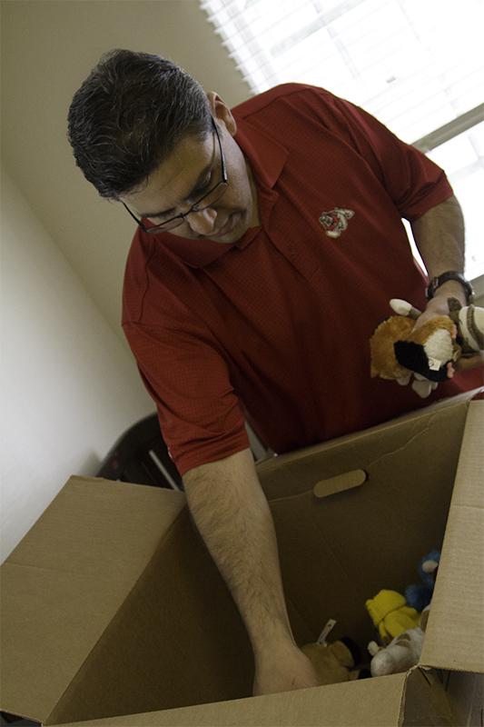 Joseph Castro unpacks his youngest son’s toys in their new home on Saturday. 
