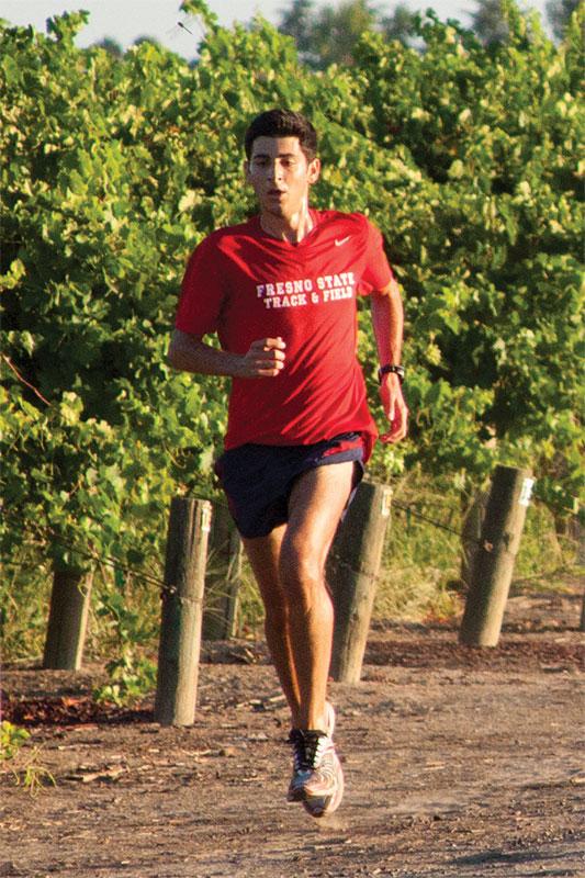 Fresno State senior Danny Vartanian runs along the vineyards near Lot Q Thursday morning. Vartanian estimates he’s logged more than 10,000 miles since arriving at Fresno State. Photo by Khlarissa Agee/The Collegian