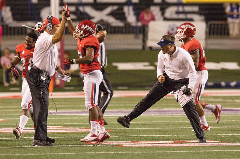 Fresno State’s defense, led by defensive coordinator Nick Toth (right), celebrate on the field during the Bulldogs’ 38-14 win over UNLV last Saturday night. Photo by Roe Borunda/The Collegian