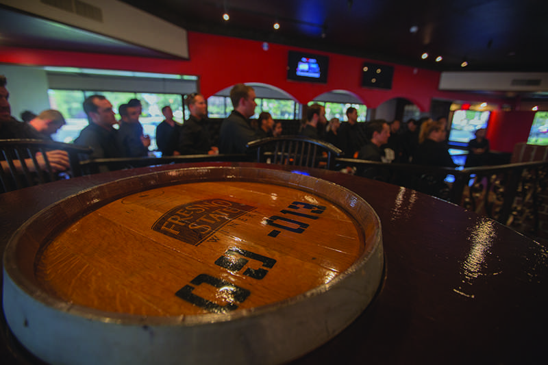 Fresno State wine barrels, previously used to make wine, are integrated into the tables inside Guri’s GrubHouse, Thursday. Photo by Darlene Wendels / The Collegian