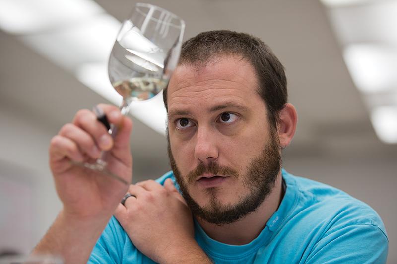 Fresno State student Steve Grande checks the clarity of his wine during the wine tasting portion of his enology class. 