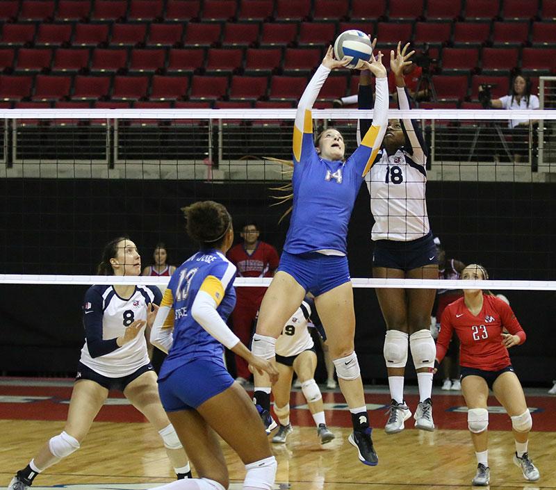 Fresno State outside hitter Zana Bowens (18) prepares to block an offering by San Jose State setter Allison Meehan during the ‘Dogs’ sweep over the Spartans Saturday at the Save Mart Center.  Photo by Logan Downing/The Collegian