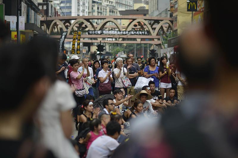 Although the crowds appear to be thinning, many people still are gathered at major points around Hong Kong, such as here in the Causeway Bay shopping district, to listen to speeches in China on Oct. 2, 2014. (Chris Stowers/Tribune News Service)