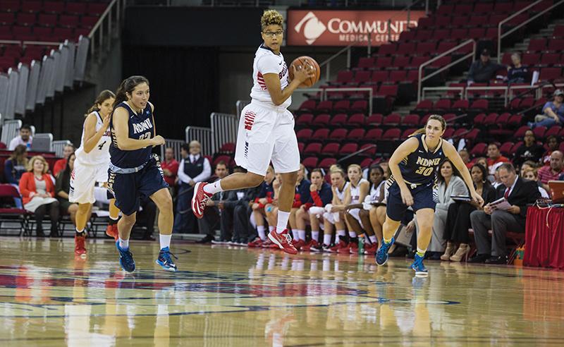 Fresno State junior guard Brittany Aikens (center) leaps as she takes the ball downcourt on a fast-break during the Dogs 89-33 victory over Notre Dame De Namur Sunday at the Save Mart Center. Photo by Darlene Wendels/The Collegian
