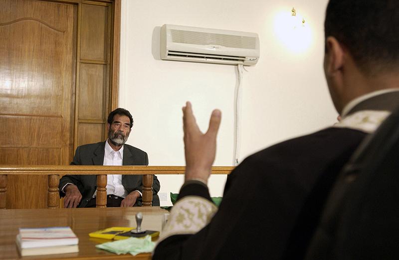 Former and deposed President of Iraq, Saddam Hussein, sits before an Iraqi judge at a courthouse in Baghdad, Iraq, where he has his initial interview to inform him of what he is being investigated for and his legal rights read to him on July, 2004. (Staff Sgt. D. Myles Cullen/U.S. Air Force)