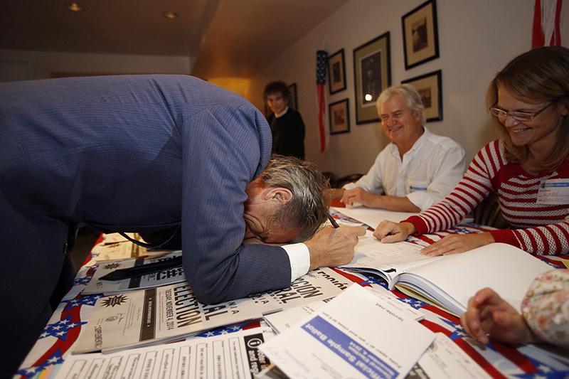 Bobby Shriver, left, laughs about signing upside down at a joke by poll clerk Aimee Goldberg, right, while signing in to vote at Carlthorp School in Santa Monica, California, on Tuesday. Shriver is a candidate for the LA County Third District Supervisorial seat running against Sheila Kuehl. (Al Seib/LA Times/TNS)