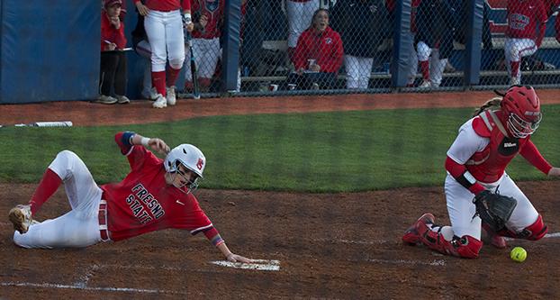 Fresno State junior infielder Whitney Smith (left) arrives to home plate safe during Tuesday’s 7-1 win over New Mexico. (Darlene Wendels/The Collegian)