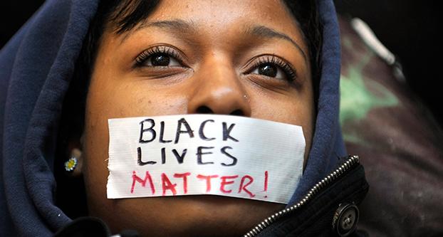 Penn State student Zaniya Joe wears a piece of tape over her mouth that says Black Lives Matter during a Ferguson protest organized by a group of Penn State University students on Tuesday, Dec. 2, 2014, in University Park, Pa. (Nabil K. Mark/Centre Daily Times/TNS)
