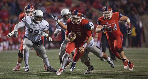 Fresno State redshirt quarterback freshman Kilton Anderson gets chased down by Nevada defenders during Thursday night’s 30-16 loss to the Wolf Pack at Bulldog Stadium. (Darlene Wendels/The Collegian)