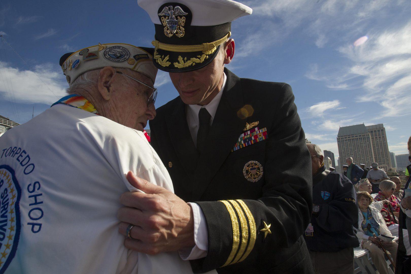 CDR Judd Krier, commander of the USS Pearl Harbor, talks with survivor Clayton Schenkelberg, 92, who worked at the torpedo shop at the time of the attack, during a ceremony to commemorate the 74th anniversary of the attack on Pearl Harbor on Monday, Dec. 7, 2015, on the USS Midway Museum in San Diego. (John Gibbins/San Diego Union-Tribune/TNS)