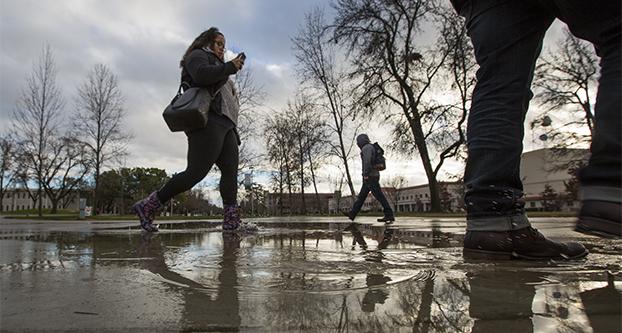Students splash through puddles in front of the Armenian Genocide Memorial during the first day of the spring 2016 semester, Tuesday, Jan. 19, 2016. Fresno got 0.76 of an inch of rain. 