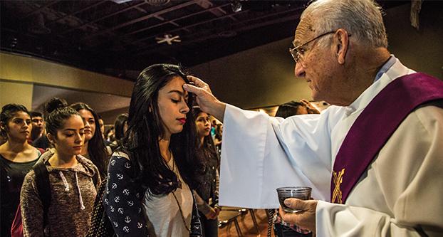 Deacon Bill Lucido begins to ash the foreheads of Fresno State students in the Satellite Student Union, Feb. 10, 2016. The markings represent the start of the Season of Lent. (Khone Saysamongdy/The Collegian)