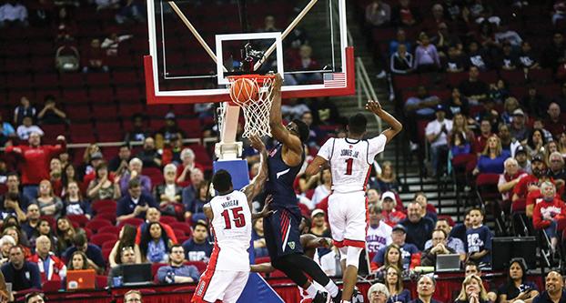 Fresno State junior forward Karachi Edo dunks between a pair of UNLV defenders during Saturday’s double-overtime, 111-104 conference win over the Rebels. (Ricky Gutierrez/The Collegian)