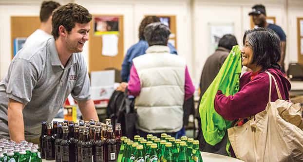 Pi Kappa Alpha member Josh Brown handling the beverages section during the food distribution at El Dorado Park, Friday, Mar. 4, 2016. Other members of the fraternity joined in as well to give a helping hand. (Khone Saysamongdy/The Collegian)