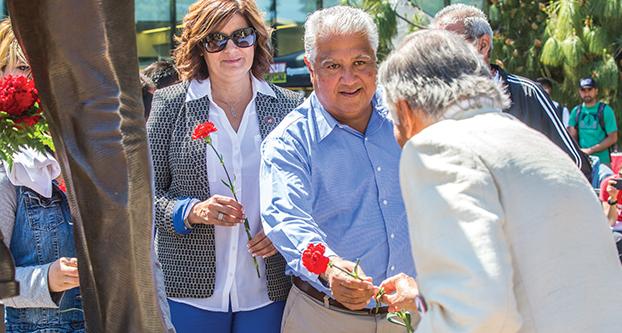 Paul Chavez hands over a rose to Dr. Sudarshan Kapoor during the Garlanding Ceremony to honor Cesar Chavez March 30, 2016. The roses are meant to pay tribute to the late activist. The commemoration also includes guest speakers, performances and refreshments. (Khone Saysamongdy/The Collegian)