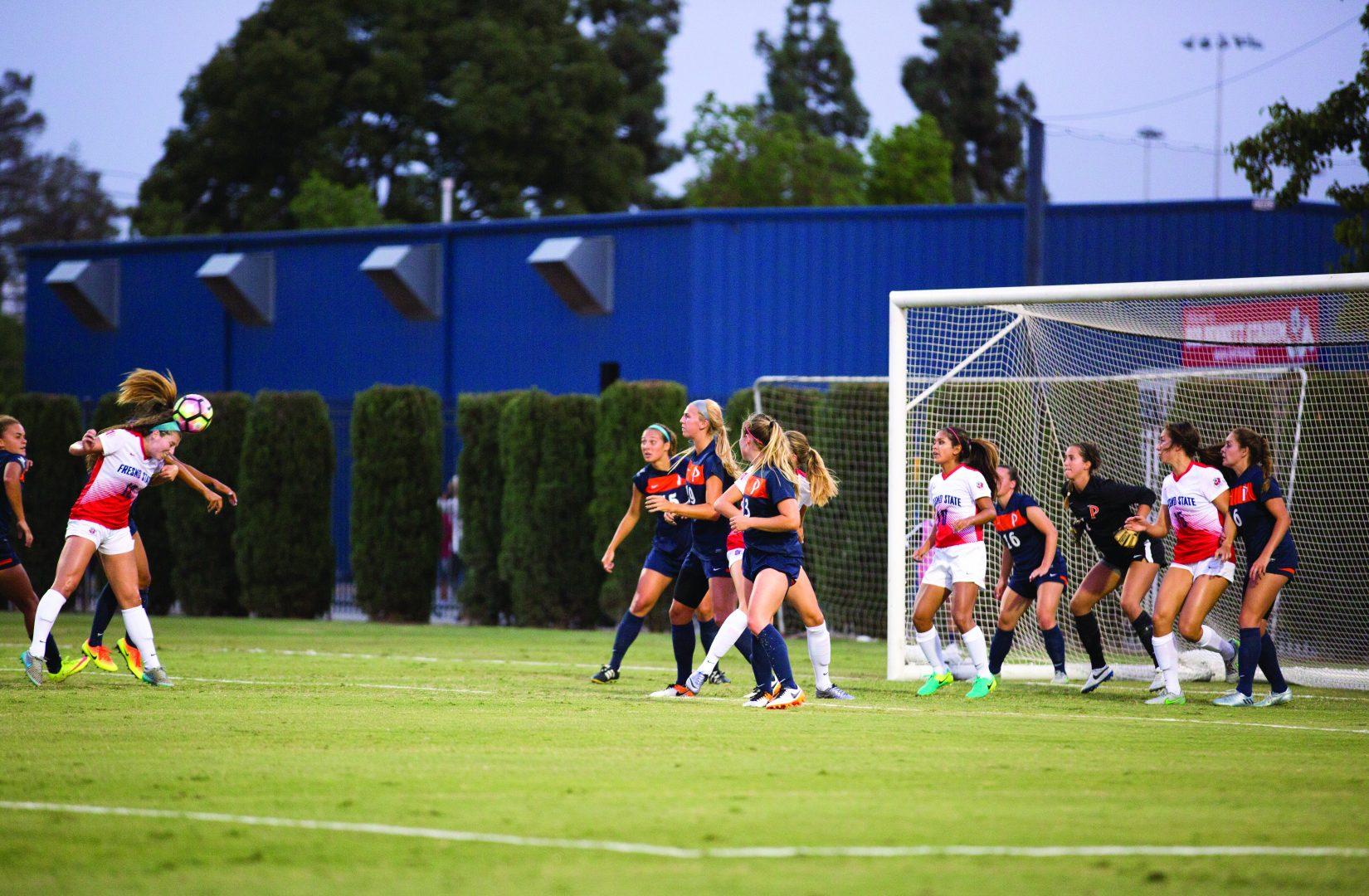 No. 12 Alyssa Holsworth attempts to score a header against Pepperdine on Friday, Aug. 26, 2016. (Christian Ortuno/The Collegian)
