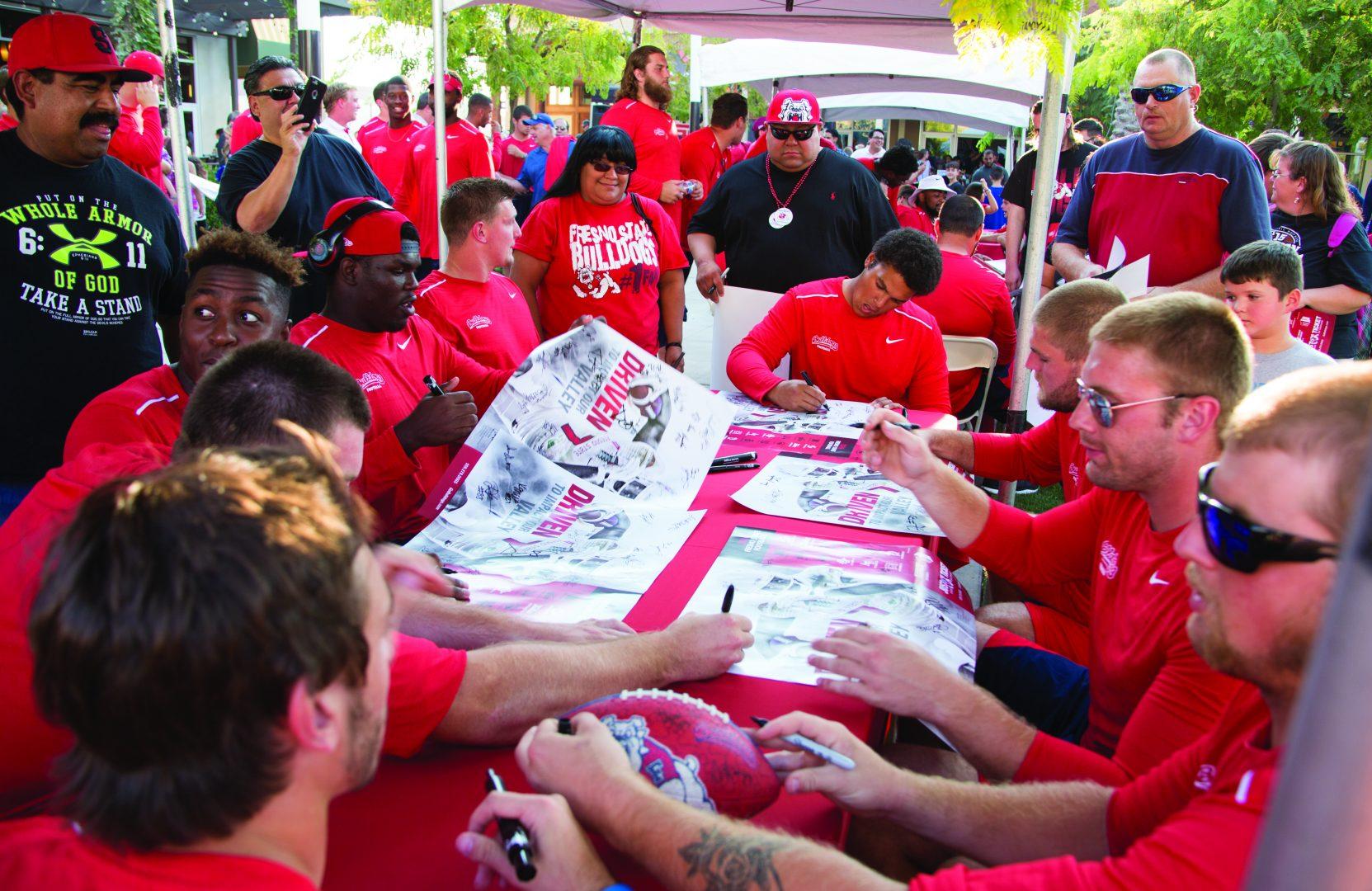 Fresno State football players sign posters during the Meet The Team event held at Campus Pointe (Christian Ortuno/The Collegian)