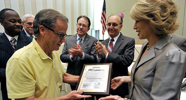 Retiring Fresno Bee reporter George Hostetter is presented by Mayor Ashley Swearengin with a plaque honoring him with George Hostetter Day for his service to the community, as members of the City Council look on. (John Walker/The Fresno Bee)
