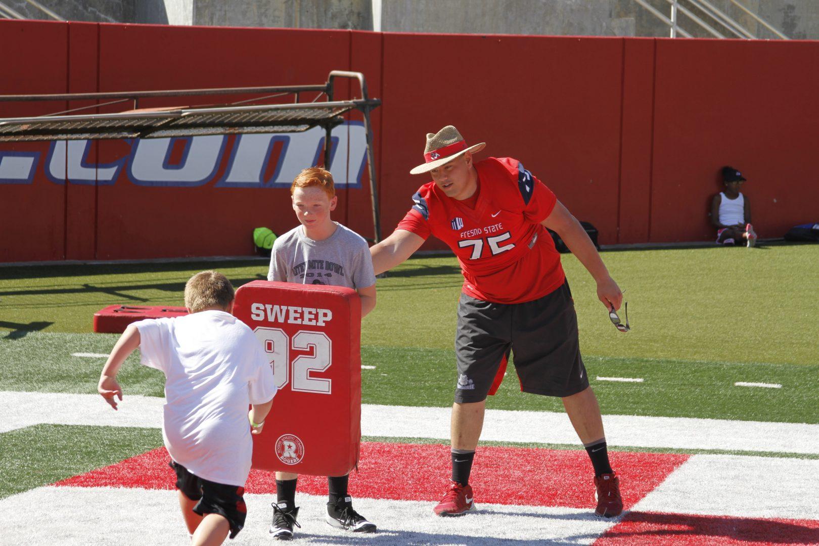 Offensive lineman Jacob Vazquez volunteers with the youth at a Bulldog football clinic. (Fresno State Athletics)