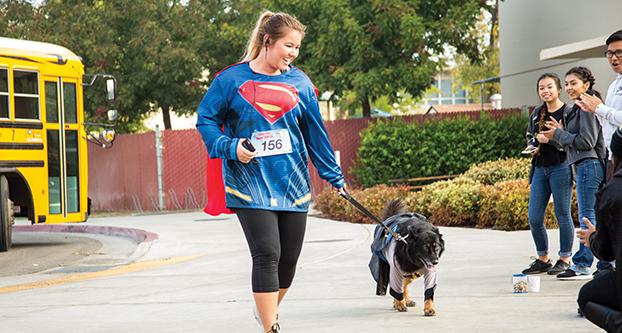 Samantha Larmer (left) jogs with her dog Dixie (right) towards the finish line during the Superhero 5k Run on Oct. 29, 2016. (Khone Saysamongdy/The Collegian)