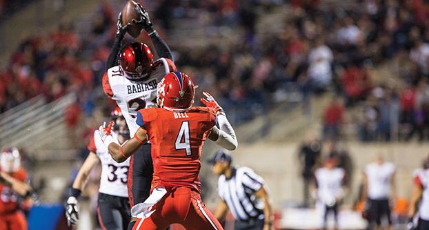 Fresno State defensive back Mike Bell (#4) prepares to tackle San Diego State’s Derek Babiash (#31) following an interception thrown by punter Blake Cusick in a failed trick play at Bulldog Stadium on Friday, Oct. 14. (Khone Saysamongdy/The Collegian)