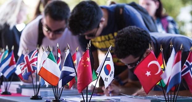 Fresno State students writing down their emails to receive more information on studying abroad and the opportunities provided at the Study Abroad Fair event on Oct. 4, 2016. (Khone Saysamongdy/The Collegian)