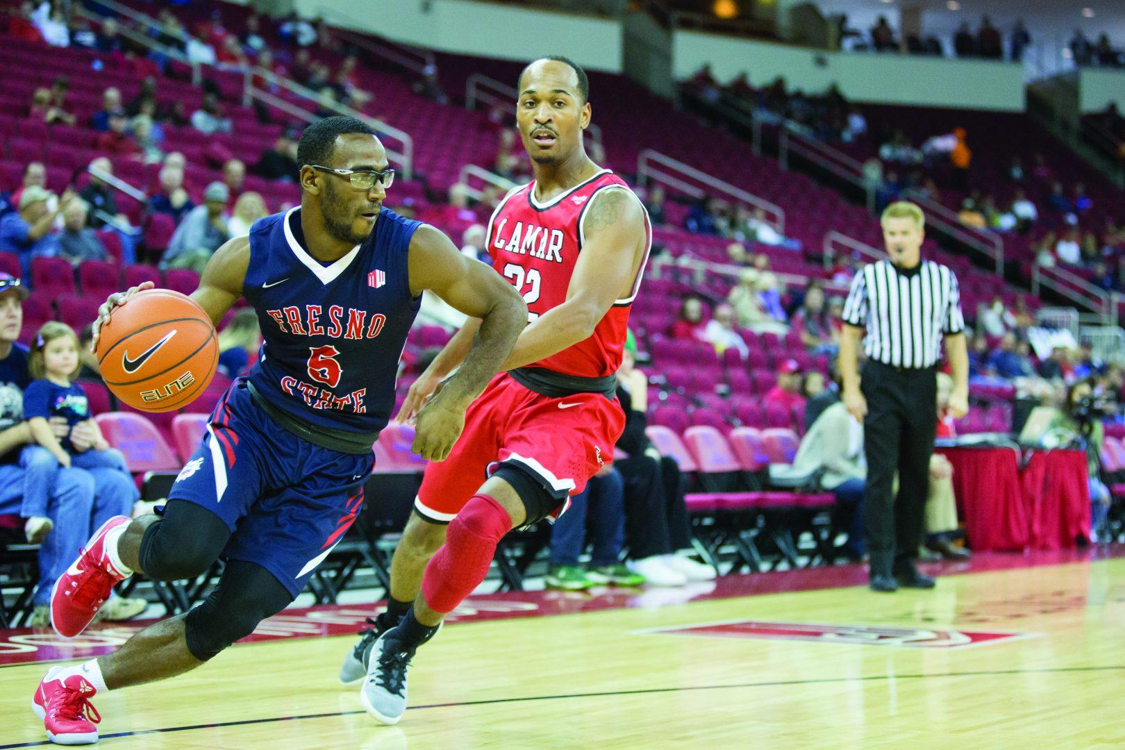 Fresno State junior guard Jammel Taylor (#5) dribbles past Lamar junior guard Joey Frenchwood (#32) on Saturday at the Save Mart Center. (Christian Ortuno/The Collegian)