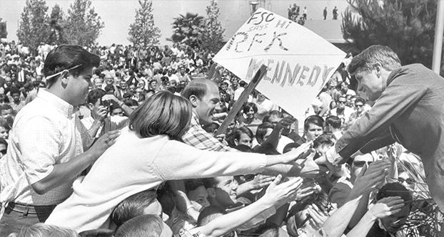 Sen. Robert F. Kennedy leans into a sea of upraised hands in the Fresno State College amphitheater, as more than 5,000 students jam the area to see and hear the Democratic presidential aspirant during his brief visit to the campus. The Kennedy charisma was also in evidence earlier at Fresno City College, and at the Fresno Air Terminal last night when the candidate was given a rousing reception. (Fresno Bee file photo)