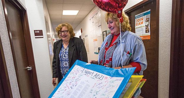 California Faculty Association Terri Prall (right) and English Professor Lisa Weston (left) with huge cards in the Peters Business Building on Feb. 14, 2017. Prall and Weston walked around the Fresno State campus getting signatures and writings from students, faculty and staff on issues such as AB 21, fee and tuition moratorium and fully funding the university. (Khone Saysamongdy/The Collegian)