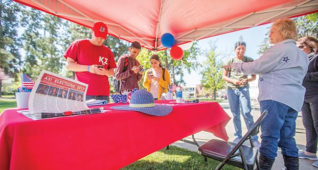 Linda Geis (right) helps inform students on candidates running for the Fresno State Associated Students Inc. near the Kennel Bookstore on March 28, 2017 (Khone Saysamongdy/The Collegian).