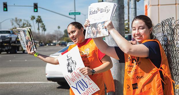 Lesly Garcia (left) and Christiana Sasso (right), on the corner of Herndon and Blackstone attempting to sell special edition Fresno Bee newspapers for Kids Day on March 7, 2017 (Khone Saysamongdy/The Collegian). 