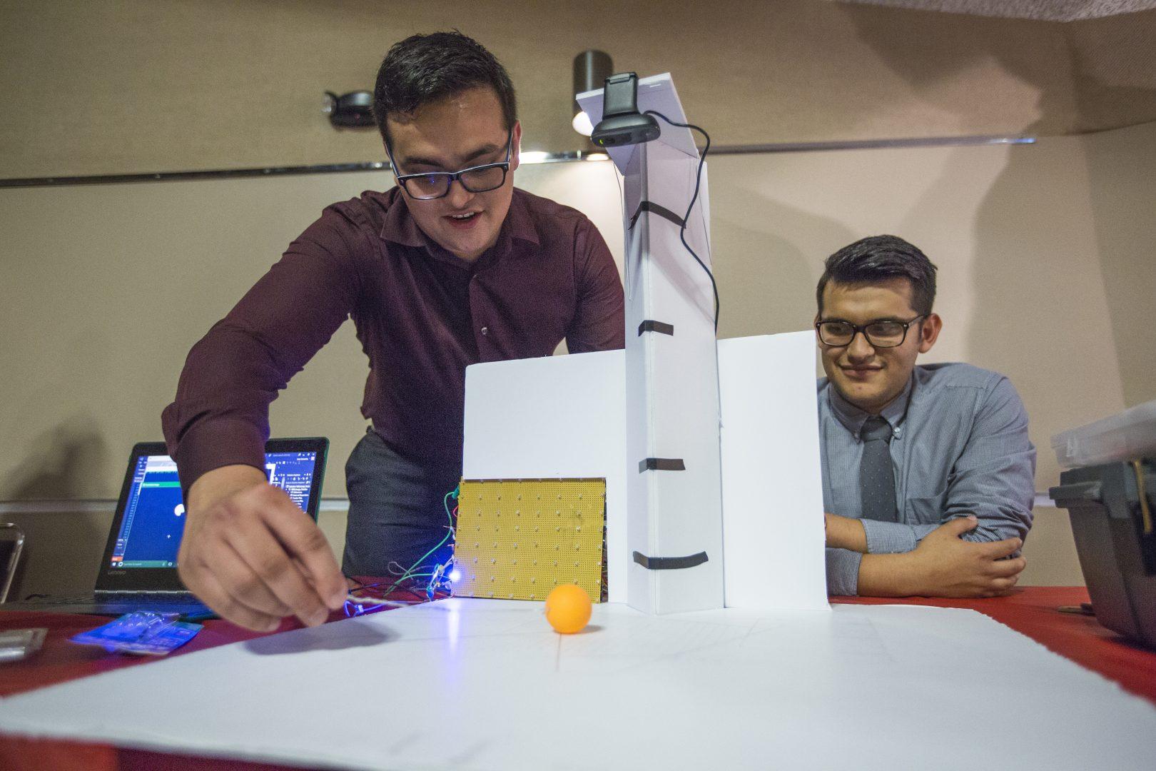 Fresno State students Jose Camacho (left) and Mauricio Cruz (right) gives a demonstration of the project, Object Tracker and Path Projection during the 10th annual Projects Day in the Satellite Student Union on May 9, 2017. The objective of the project is to track an object and indicate its path with the use of a camera, visual studio and OpenCV. For this project, students tracked a ping-pong ball and used LED lights to illuminate its path. (Khone Saysamongdy/The Collegian)