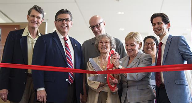 Fresno State faculty members gather around Philip Levine’s wife as she cuts the ribbon to the new Philip Levine Reading Room, Friday, May 5, 2017. The room contains a collection of Philip Levine’s books and has pictures hung that were provided by his wife, Frances. Pictured left to right, Peter Mcdonald, Dr. Joseph Castro, C.G. Hanzlicek, Frances J. Artley, Dr. Lynnette Zelezny, Gloria Montez, Dr. Saul Jimenez-Sandoval. (Daniel Avalos/ The Collegian)