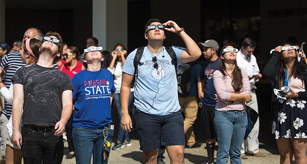 Fresno+State+students+wear+their+eclipse+viewing+glasses+to+get+a+glimpse+of+the+partial+eclipse+over+Fresno.+The+eclipse-viewing+event+took+place+outside+the+Engineering+East+Building+on+Aug+21%2C+2017.+%28Daniel+Avalos%2FThe+Collegian%29