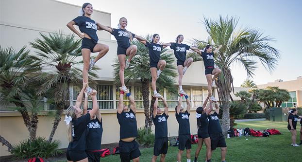 The Fresno State cheer team practicing outside the South Gym on campus, Sept. 20, 2017. The team is practicing their stunts as they prepare for game days and events. (Daniel Avalos/ The Collegian)