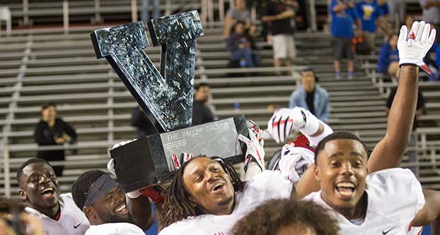 Fresno State players celebrate with the Valley Trophy after defeating San Jose State 27-10. (Nugesse Ghebrendrias/The Collegian)