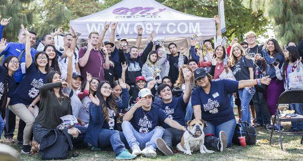 People in attendance at National Student Day come to the Q97 booth for a group picture in front of the Kennel Bookstore on Oct. 11, 2017. (Daniel Avalos/The Collegian)