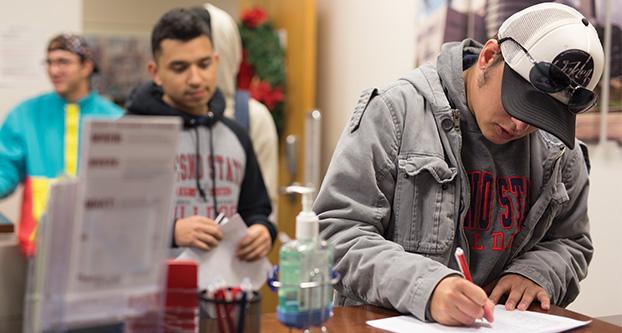 Students wait in line in the ASI office in the University Student Union Room 316 on Nov. 28, 2017. The students are purchasing $15 tickets to go on a round trip bus ride to Boise, Idaho to support Fresno State at the Mountain West Championship game against Boise State. (Daniel Avalos/The Collegian)