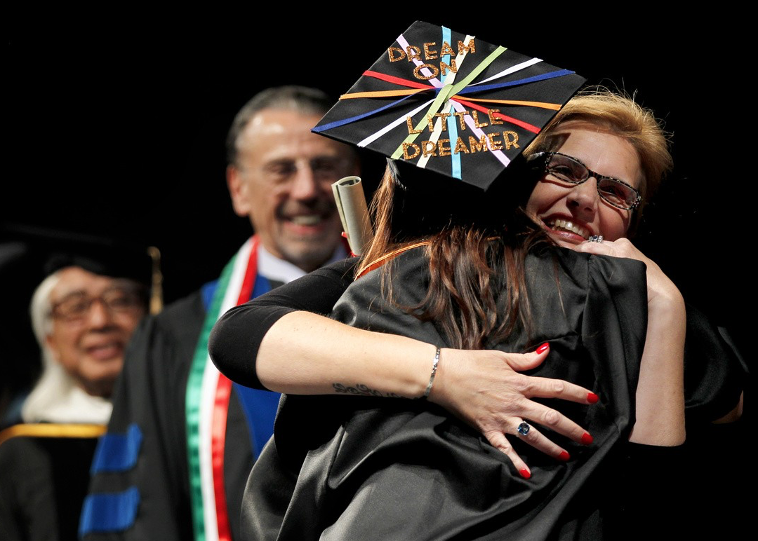 Fresno State first lady, Mary Castro, hugs a graduating student. It has become customary for Castro to hug students walking across the stage when graduating. (Courtesy of Fresno States Facebook)
