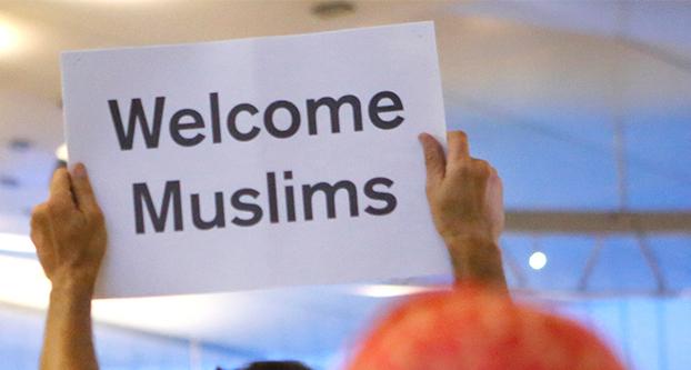 John Wilder, background, welcomes Muslims to the United States at the Tom Bradley International Terminal of LAX in Los Angeles on June 29, 2017, protesting President Trumps travel ban. (Christian K. Lee/Los Angeles Times/TNS)
