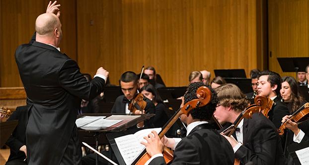 Fresno State music department conductor leads the orchestra throughout the Faculty Music Concert on Saturday night. (Aly Honore/The Collegian)
