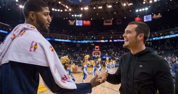 Former Fresno State star athletes Paul George (left) and Derek Carr (right) greet each other during a Golden State Warriors vs Indiana Pacers game at the Oracle Arena in Oakland, California, on Monday, Dec. 5, 2016. (Courtesy of Fresno State Athletics)