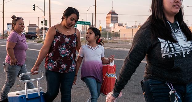 Jasmine Castillo and her family walk down Santa Clara avenue near the Poverello House handing out free burritos and hygiene products for Castillos birthday on April 13, 2018. (Ramuel Reyes/ The Collegian)