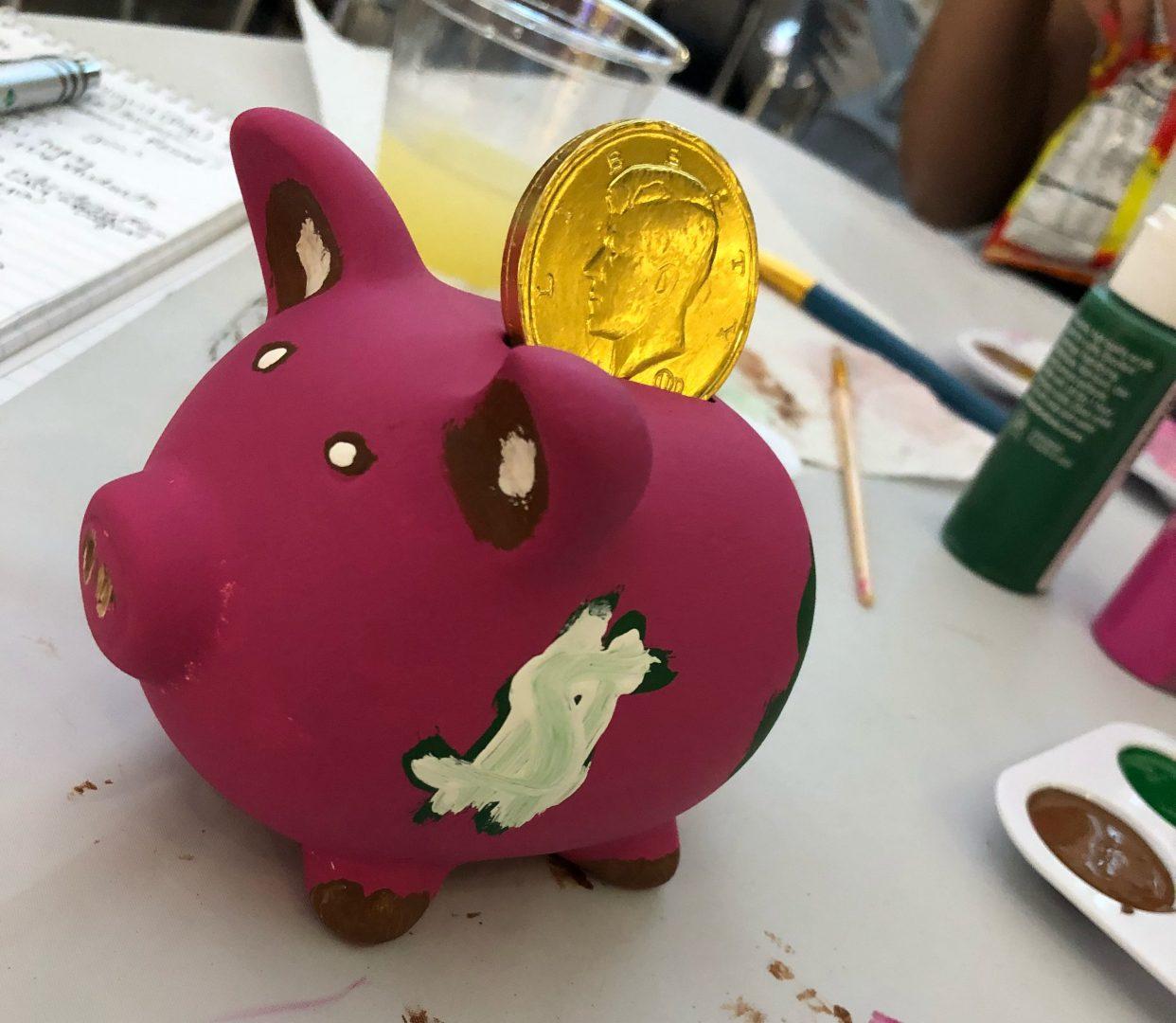 Students learn about finances by painting piggy banks
