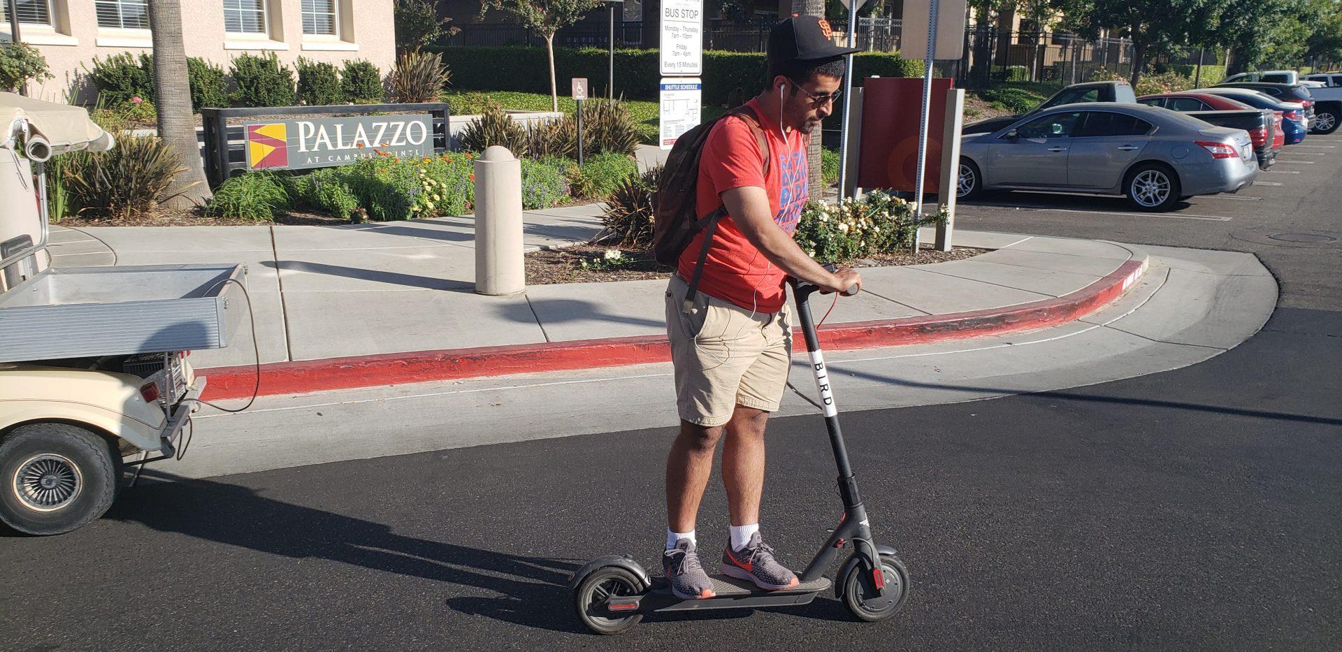 A Fresno State sophomore rides a Bird scooter outside the Palazzo at Campus Pointe on Sept. 7. The City of Fresno announced it issued a cease and desist order to the scooter company. (Seth Casey/The Collegian) 