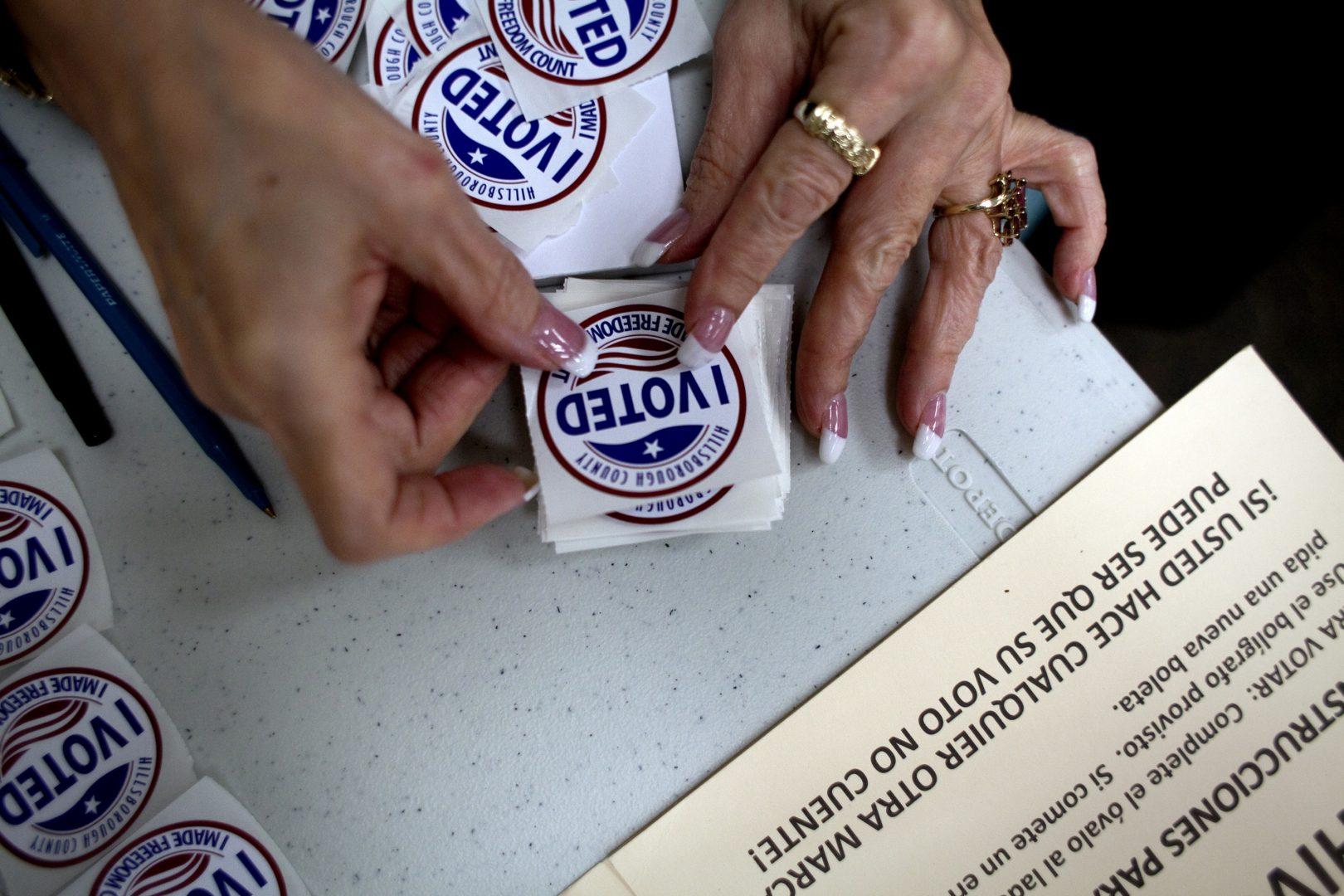 A poll worker gets I Voted stickers ready to hand to voters as they finished up at the ballot booths at Jan Kaminis Platt Regional Library in South Tampa, Fla., on November 6, 2012. (Carolina Hidalgo/Tampa Bay Times/TNS)